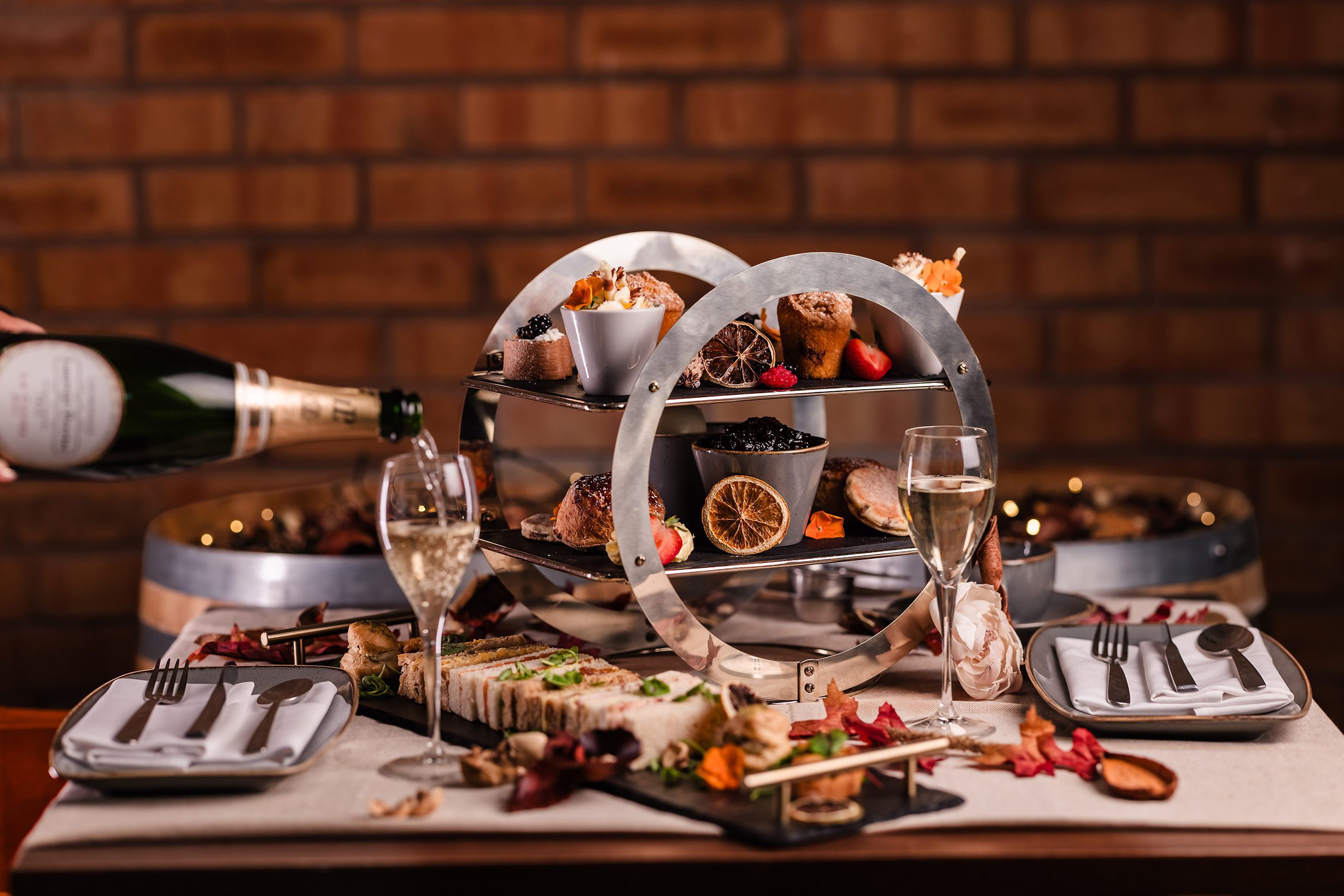 A bottle of champagne is poured beside dessert and appetisers, perfect for hotel breaks South Wales style.