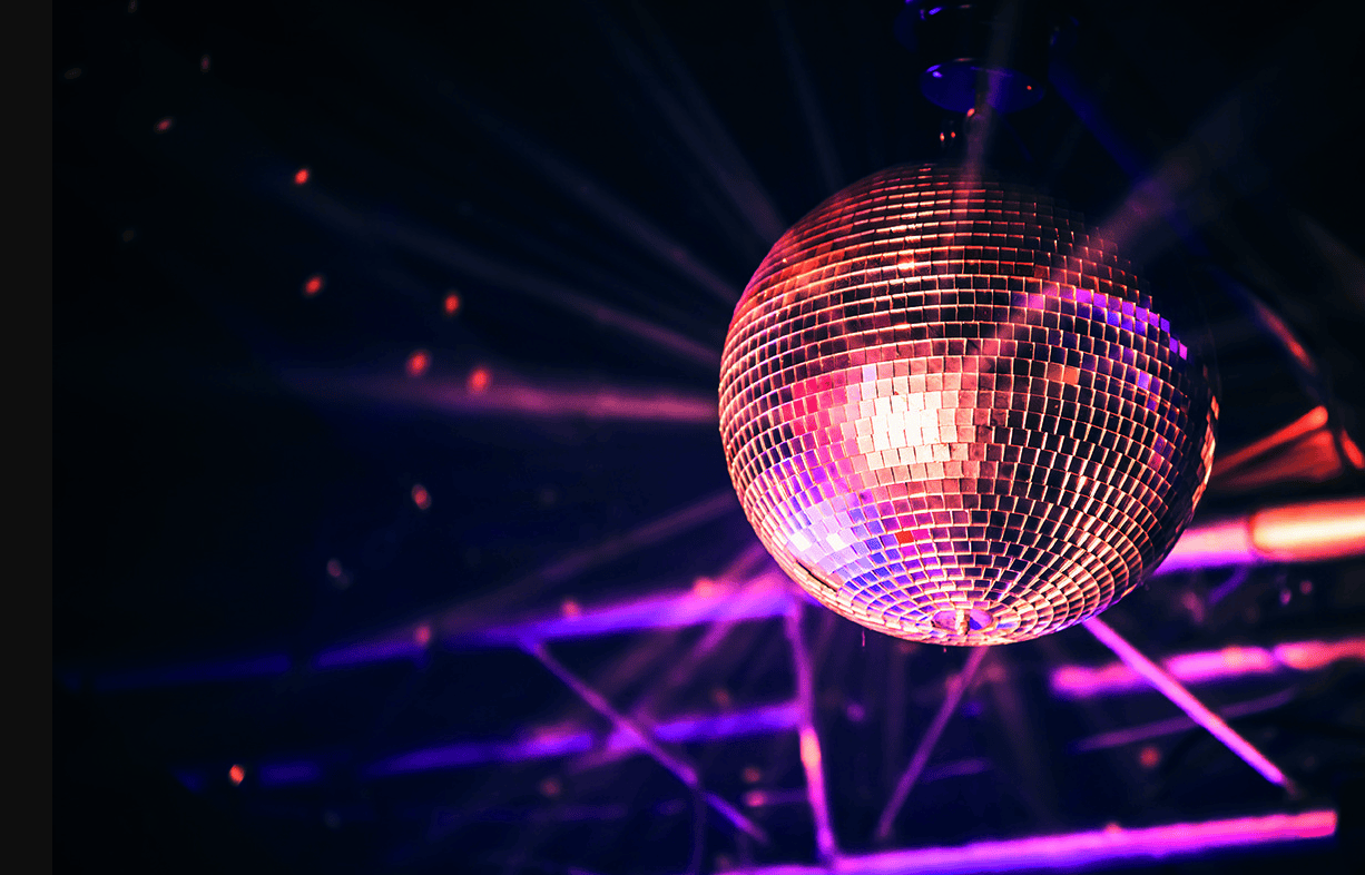 A disco ball hangs overhead, reflecting purple and pink beams—perfect ambience for trendy baby showers.